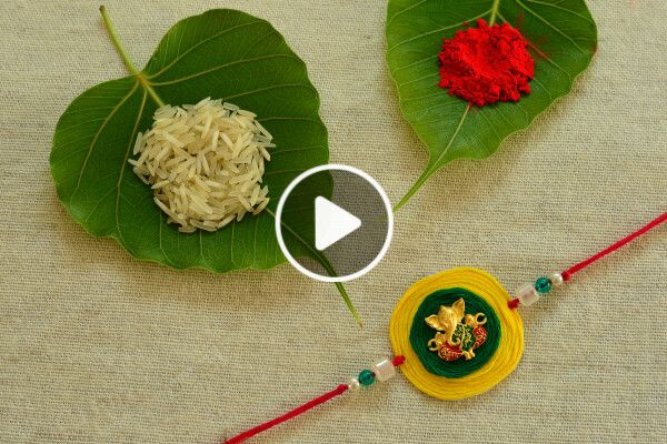 two leaf shaped decorations on top of green leaves with red and yellow flowers in the middle