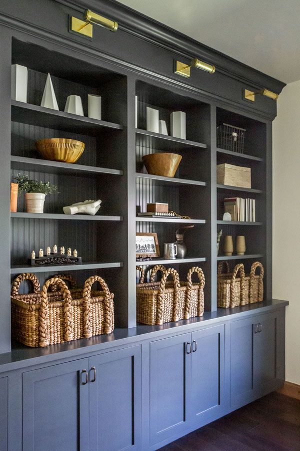 an empty bookcase with baskets and books on it