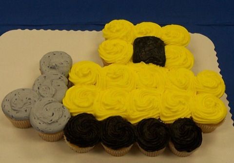 cupcakes are arranged in the shape of a train on top of a sheet cake