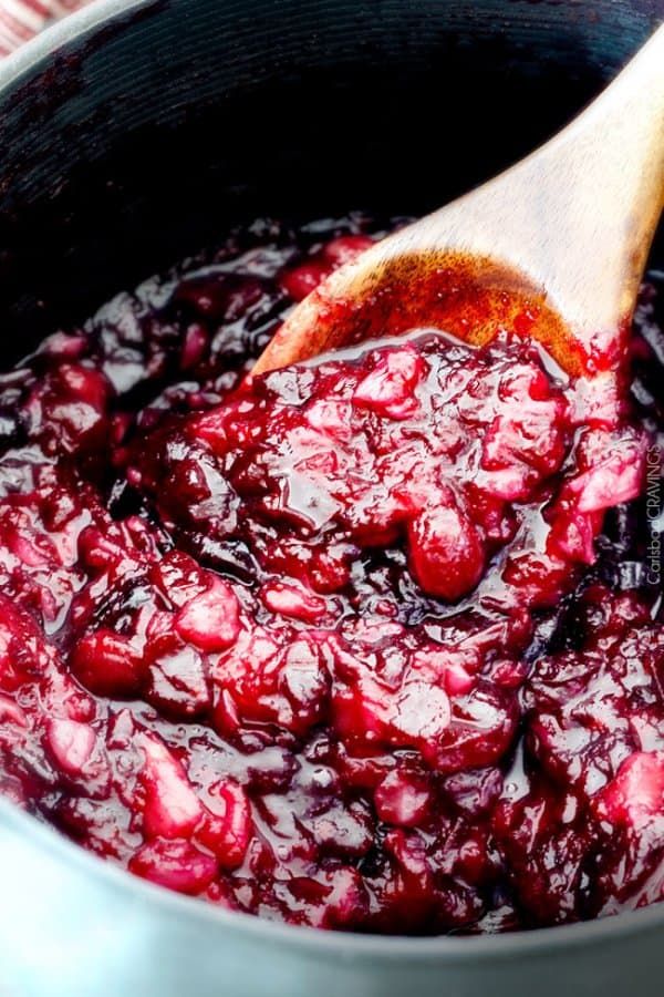 cranberry sauce in a pot with a wooden spoon