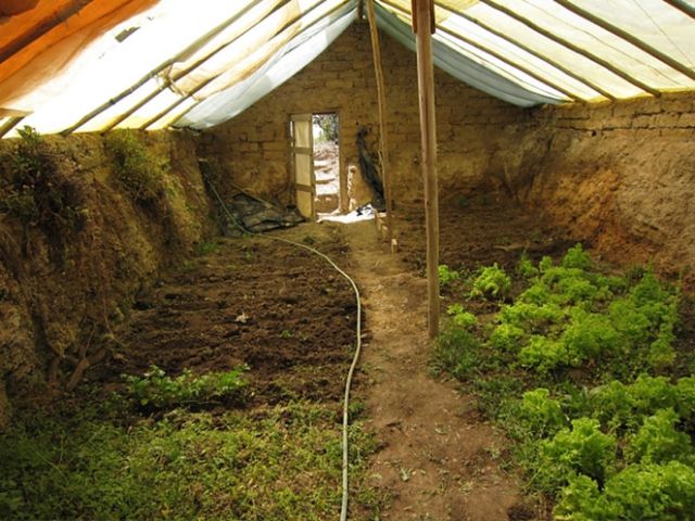 the inside of a building with dirt and grass