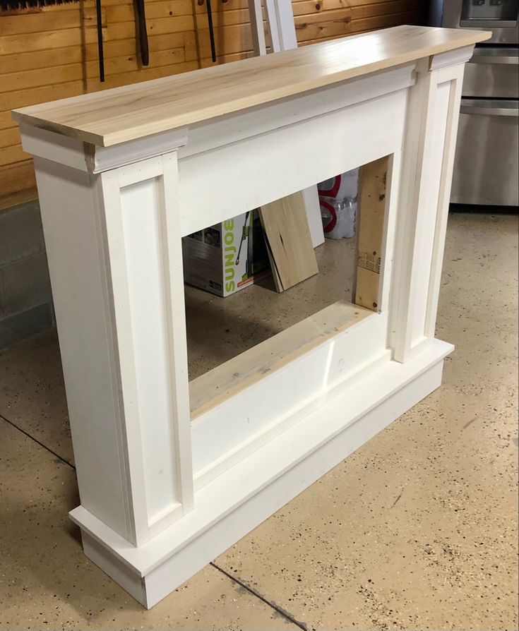 an unfinished white fireplace mantle in a kitchen