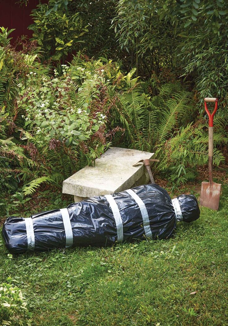 a large bag sitting on top of a lush green field next to a wooden bench