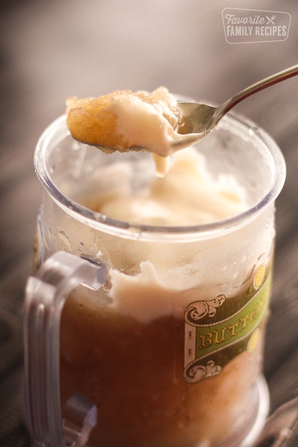 there is a spoon with some ice cream in it and the words frozen butter beer