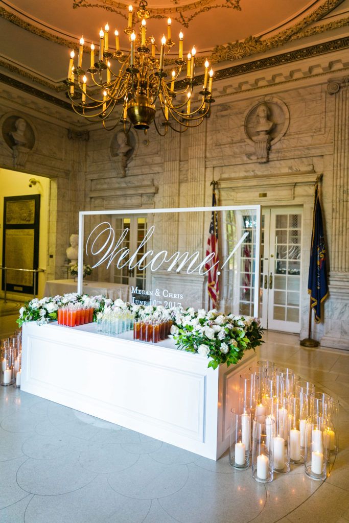 candles and flowers are placed in front of a glass sign