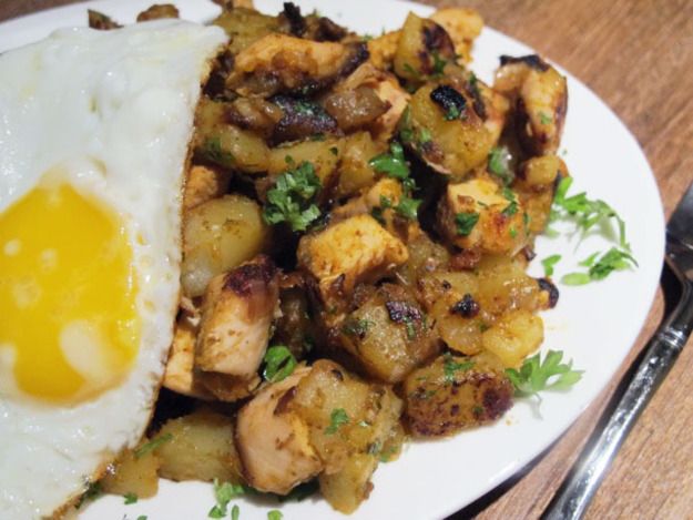 an egg is on top of some fried potatoes