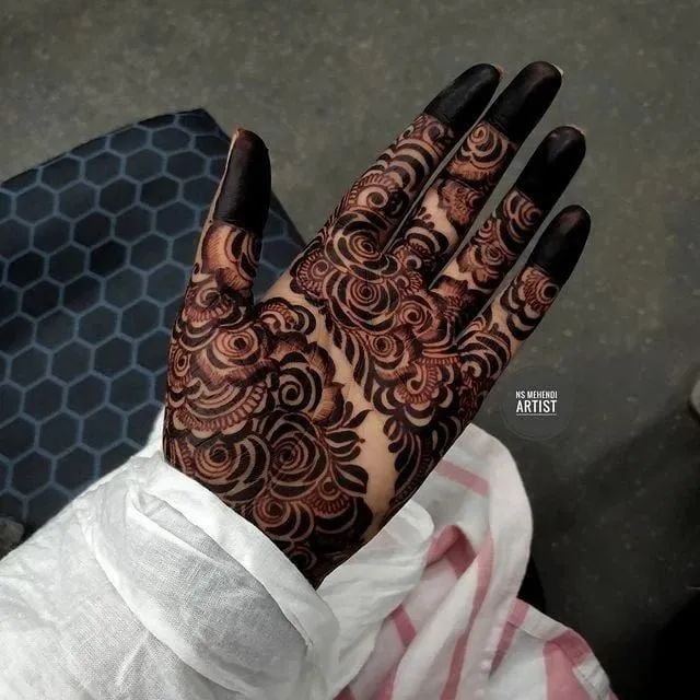 a woman's hand with henna tattoos on it