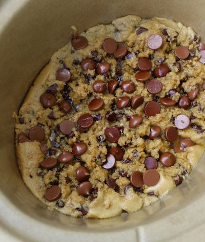 an uncooked pizza with chocolate chips and other toppings in a crock pot