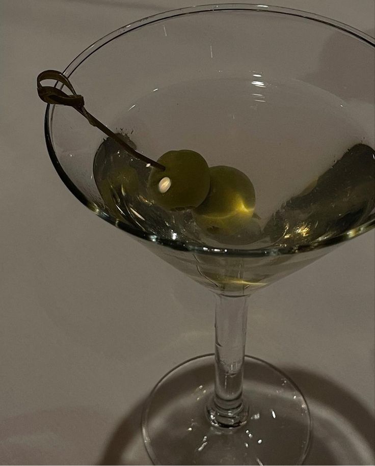 a martini glass with olives in it