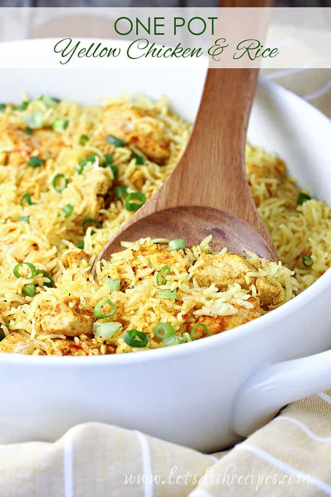 one pot yellow chicken and rice in a white dish with a wooden spoon