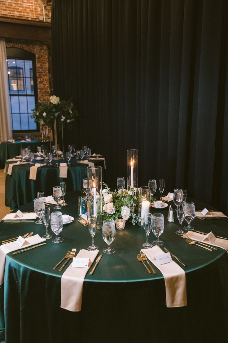 the table is set up with place settings and wine glasses for dinner guests to enjoy