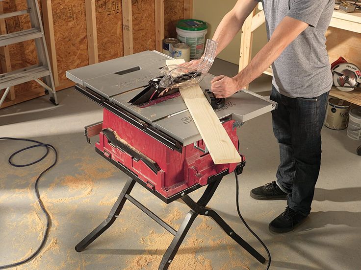 a man working on a table sawing wood