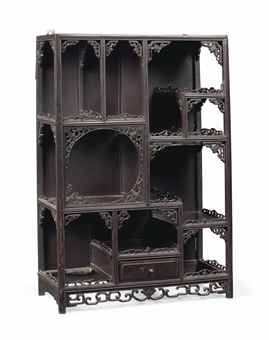 an ornate wooden shelf with drawers and shelves on each side, in the shape of bookshelves