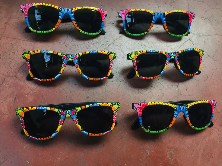 six pairs of colorful sunglasses sitting on top of a floor next to each other with black lenses