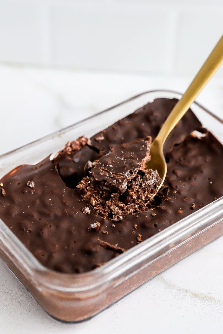 chocolate ice cream in a plastic container with a spoon