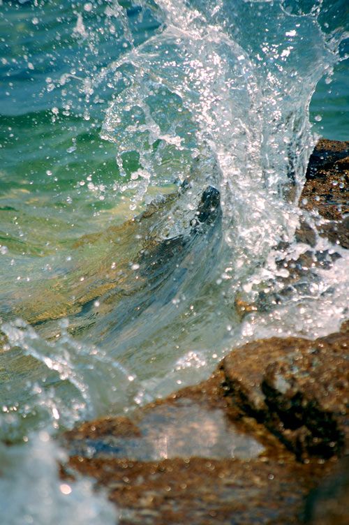 the water is splashing over the rocks in the ocean