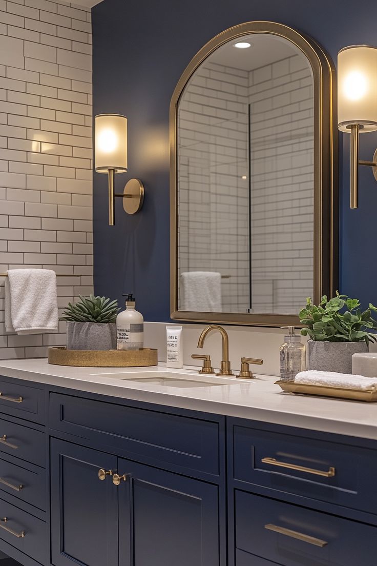 a bathroom with blue cabinets and gold accents