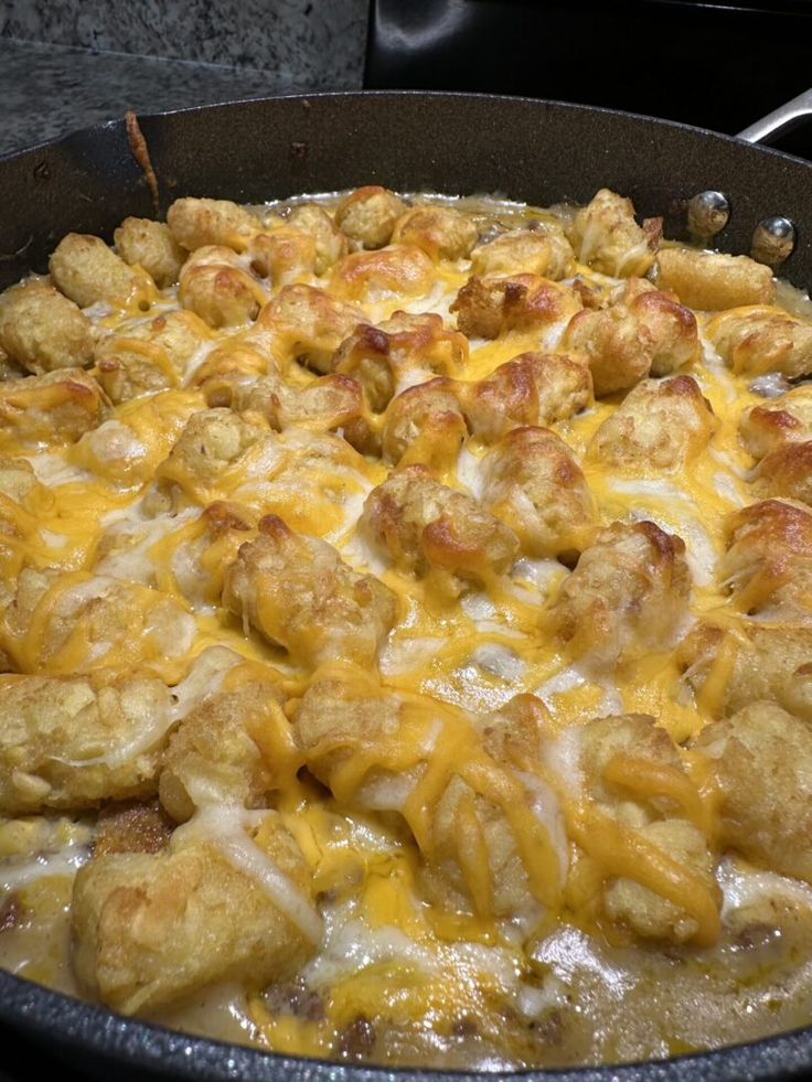 a skillet filled with chicken and cheese covered in sauce