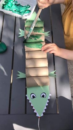 a child is making a paper snake out of cardboard