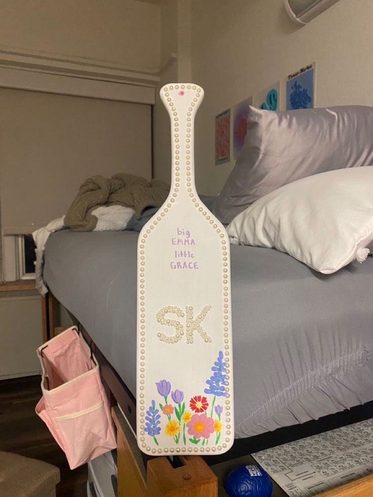 a bottle shaped sign sitting on top of a bed next to pillows and other items