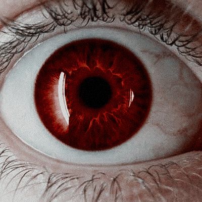 an eye with red iris and long eyelashes