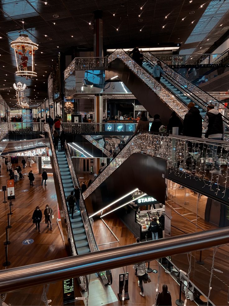 an escalator in a shopping mall with people walking up and down the stairs