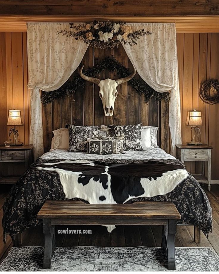 a bed room with a neatly made bed and a cow head on the wall