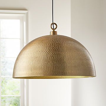 a large brass pendant light hanging from a ceiling