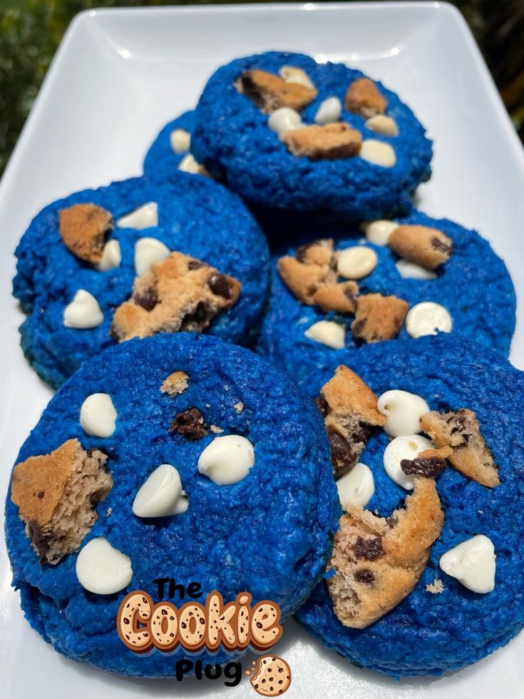 blue cookies with white chocolate chips and marshmallows are on a white plate