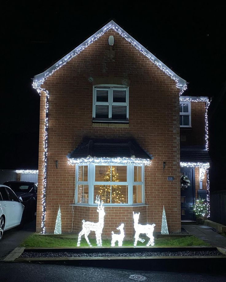 a house decorated with christmas lights and reindeer figures