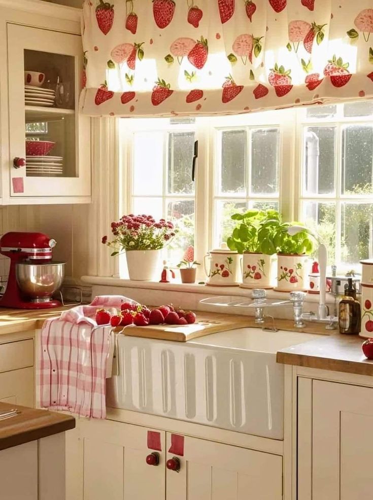 a kitchen with white cabinets and red curtains