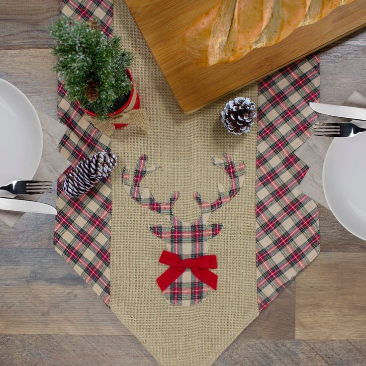 the table is set with place mats, plates and utensils for christmas dinner