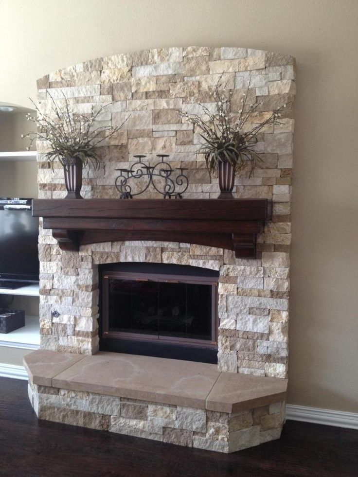 a stone fireplace with potted plants on top