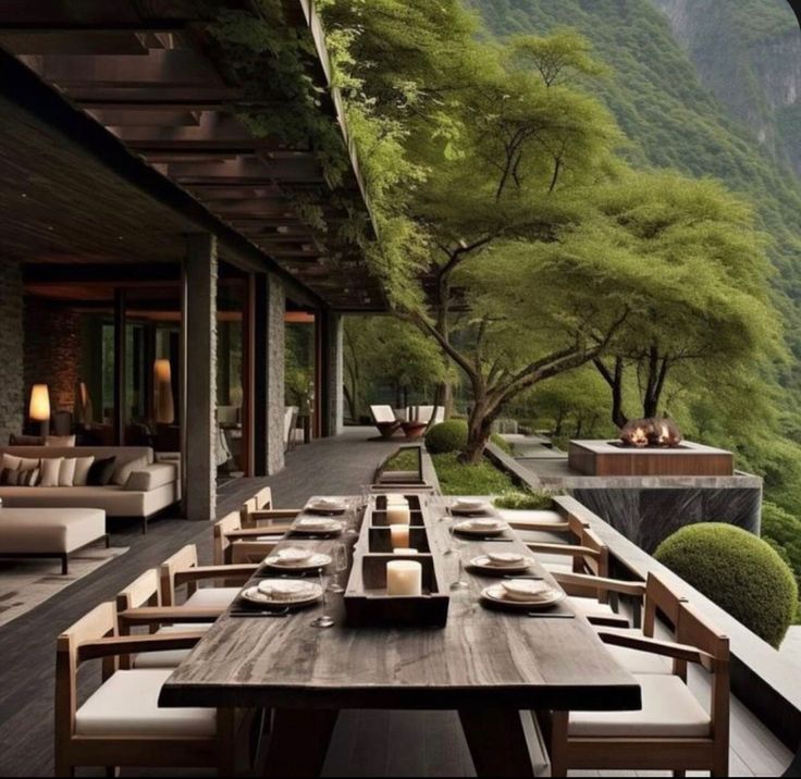 an outdoor dining area with wooden tables and chairs, overlooking the mountain range in the distance