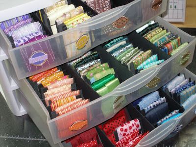 several plastic containers filled with different types of sewing supplies