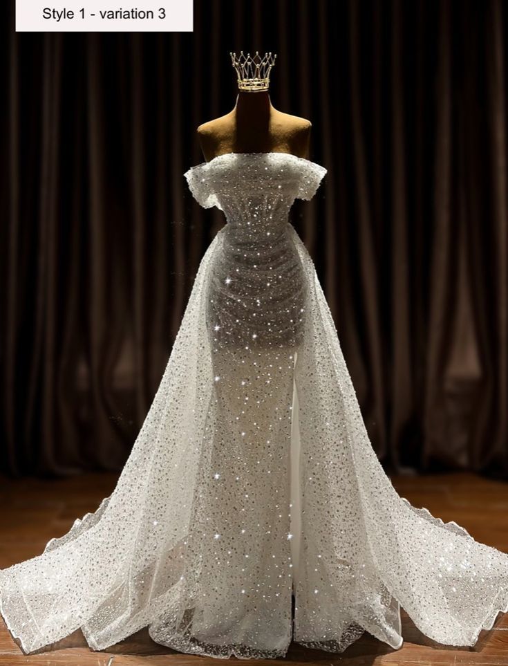 a white wedding dress with sequins on the skirt and a crown on top