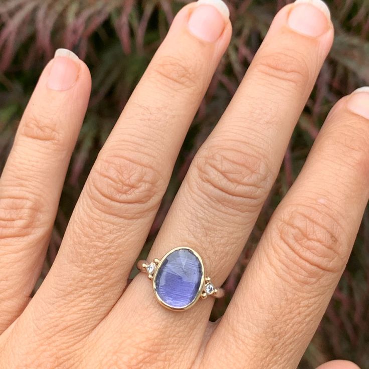 A vibrant purple Iolite is set between two brilliant white diamonds. Set in 14k yellow gold with a sterling silver seagrass band this ring will quickly become a favorite. Approx stone size: 13mm x 10mm Approx stone weight: 2.4cts Mohs Hardness: 7-7.5 This one of a kind piece is handmade with love in Emily's Hudson Valley studio. If you have questions about sizing, shipping or need help deciding on your perfect piece please reach out to us! Stacked Engagement Ring, Birthstone Stacking Rings, Imperial Topaz, Vibrant Purple, Local Jewelry, Diamond Shop, London Blue Topaz, Hudson Valley, Jewelry Rings Engagement