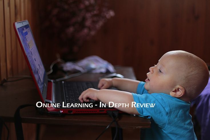 a baby is playing with a laptop computer