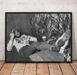 a black and white photo of a man laying on the floor with his feet up