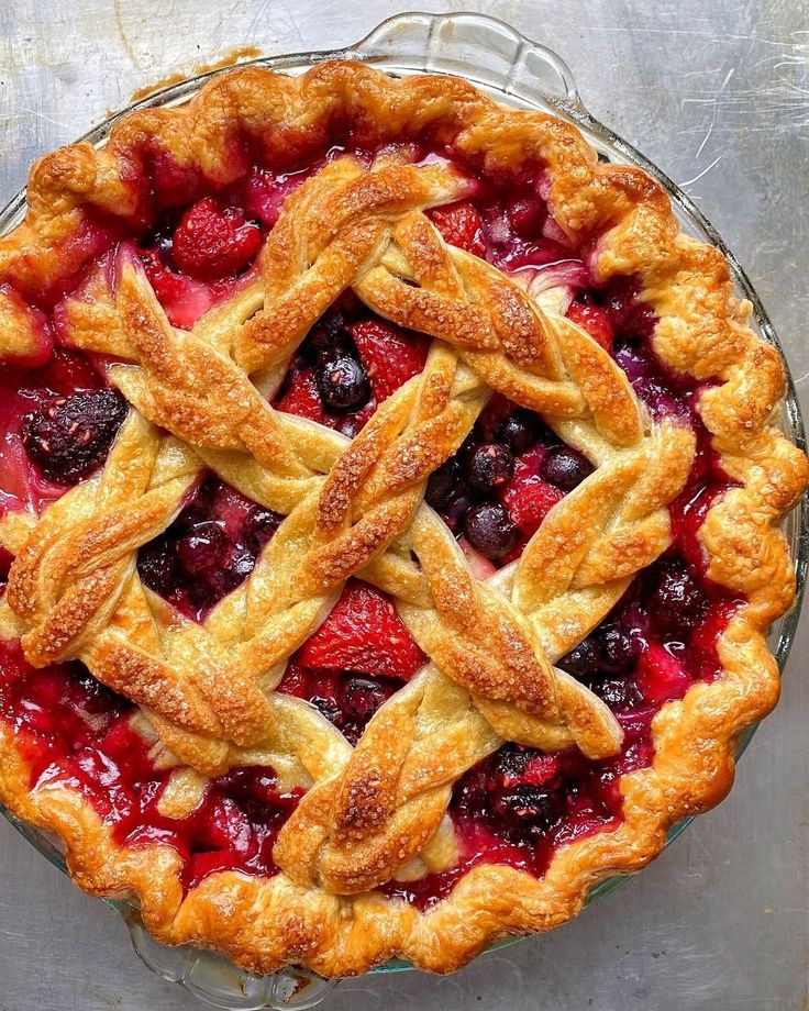 a pie topped with fresh fruit and latticed crust