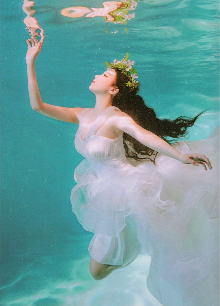 a woman in a white dress under water