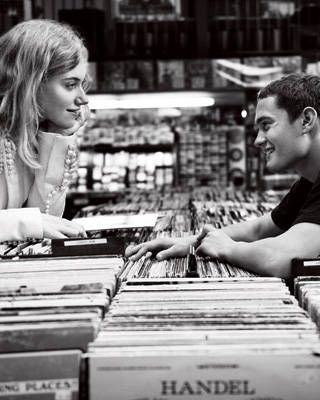 a man and woman looking at records in a store