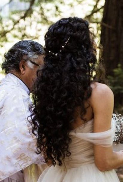 a bride and groom kissing in the woods