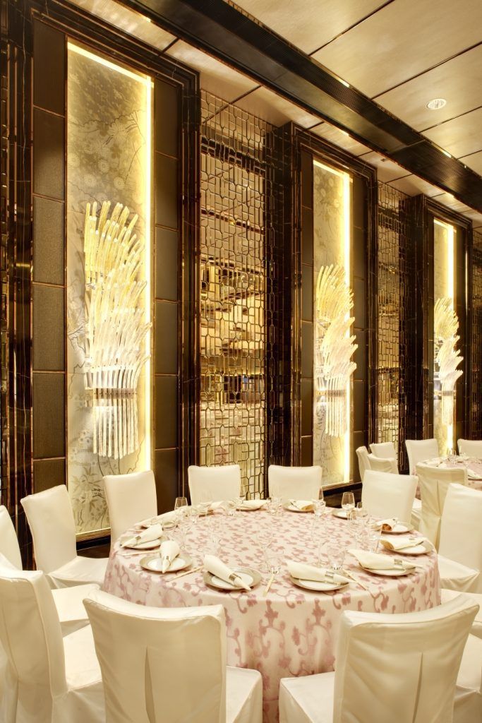 a banquet room with white chairs and tables