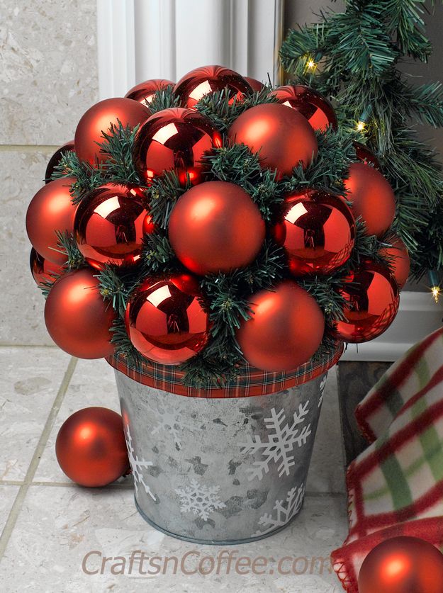 a potted plant filled with red christmas ornaments