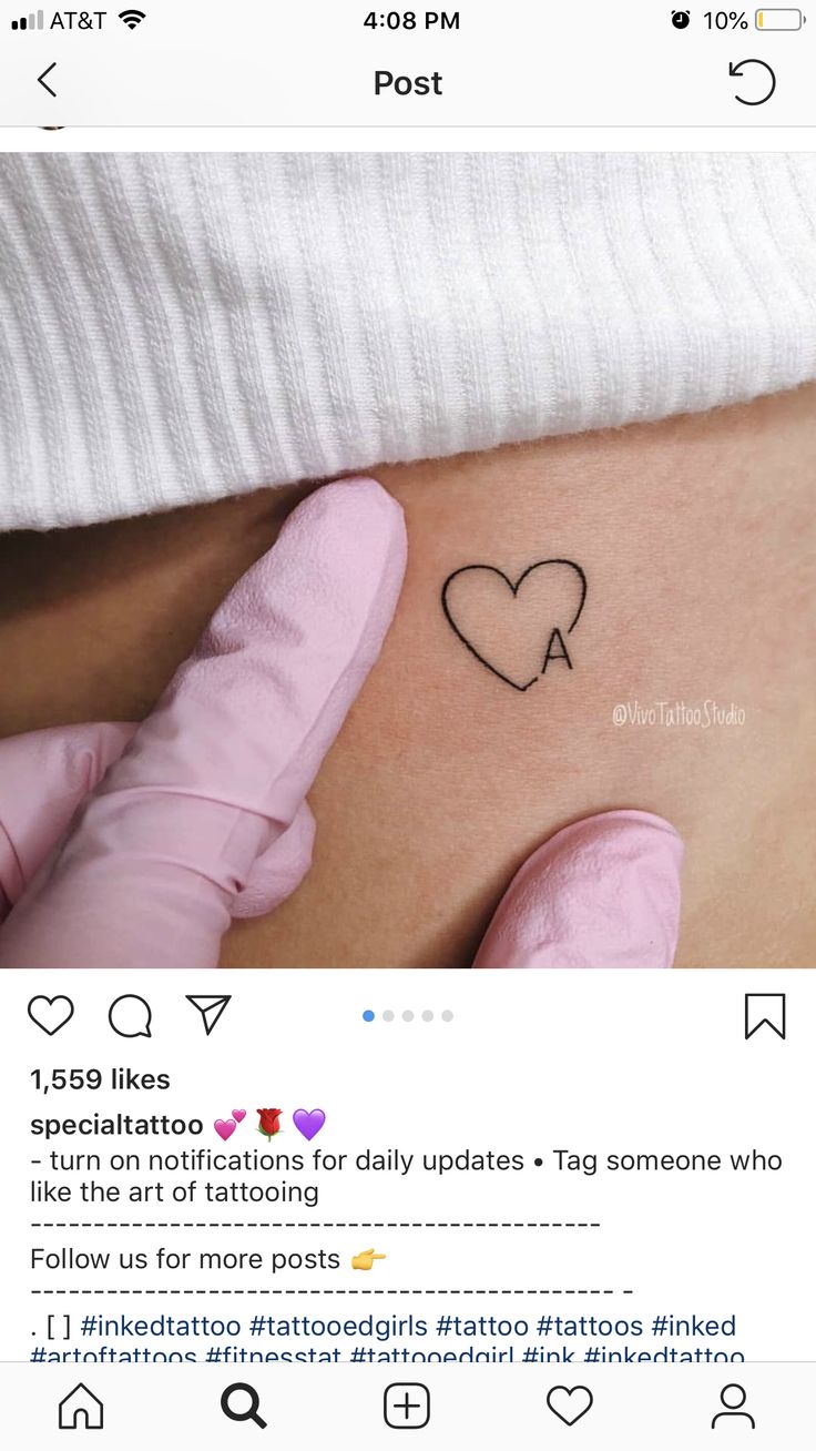 a woman's stomach with a heart tattoo on it