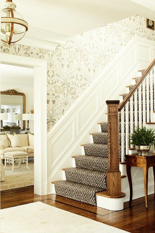 the stairs in this house are decorated with wallpaper and rugs, along with an entryway