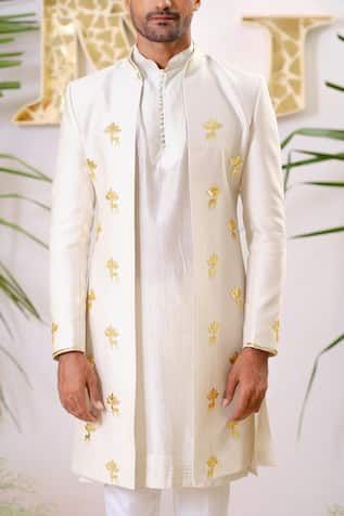 Dusty ivory full sleeve sherwani with gold reindeer, filigree lotus applique embroidered motifs and cutpipe embellishment. Paired with solid kurta and pant pyjama. 
Components: 3
Pattern: Embroidery, Embellished
Type Of Work: Cutpipe
Neckline: Mandarin collar
Sleeve Type: Full sleeves
Fabric: Sherwani and Kurta: Chanderi Silk, Pant Pyjama: Vegan Silk
Color: Ivory
Other Details: 
Kurta Closure: Front potli buttons
Disclaimer: The fabrics used, are handwoven, hence may have impurities or slubs/var Cream Sherwani With Cutdana Work, Off White Ceremonial Sherwani For Festive Occasions, Cream Bandhgala With Long Sleeves For Diwali, Cream Long Sleeve Bandhgala For Diwali, Designer Cream Kurta With Cutdana, Designer Off White Kurta For Eid, Designer Off-white Kurta For Eid, Festive Ceremonial Off White Kurta, Ceremonial Off White Sherwani For Festive Occasions