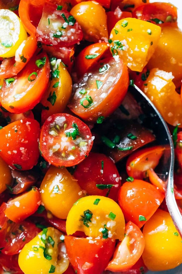 a bowl filled with lots of different types of tomatoes and cheese on top of it