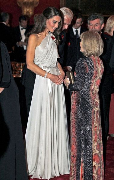 two women standing next to each other in front of an audience at a formal event